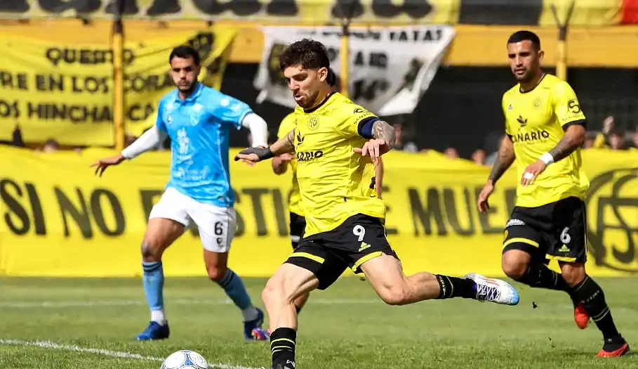 Flandria derrotó a Defensores Unidos de Zárate en el Carlos V, sumó tres puntos fundamentales y logró superar a un rival directo en la tabla de posiciones. Flandria consiguió una victoria clave en su pelea por alejarse de los últimos puestos. En el Estadio Carlos V, el equipo de Jáuregui derrotó 1 a 0 a Defensores Unidos de Zárate con un gol de Matías Donato y aprovechó el resultado para superar a su rival en la tabla de posiciones. El triunfo tuvo un valor especial porque llegó en un encuentro en el que el Canario generó situaciones para ampliar la diferencia, aunque también sufrió por las oportunidades desperdiciadas. El conjunto dirigido por Jesús Díaz afrontó el compromiso con la necesidad de sumar de a tres para mejorar su situación. [ez-toc] Después del empate 1 a 1 frente a Comunicaciones en la fecha anterior, el entrenador introdujo varias modificaciones en la formación inicial con el objetivo de encontrar respuestas futbolísticas y conseguir un resultado que le permitiera tomar distancia de uno de los equipos que también pelea en la zona baja. Flandria encontró la ventaja en el primer tiempo El comienzo del partido mostró un desarrollo equilibrado, aunque Defensores Unidos consiguió generar las primeras situaciones de peligro. El conjunto visitante buscó aprovechar los espacios y estuvo cerca de abrir el marcador en dos oportunidades que encendieron las alarmas en el equipo local. La primera llegada clara se produjo después de un desborde de Alarcón, quien envió un centro atrás para Alan Sombra. El futbolista conectó la pelota desde la puerta del área chica, pero su remate se marchó apenas desviado. La acción evidenció las dificultades iniciales de Flandria para controlar los avances del conjunto zarateño. Poco después, Martín Giménez probó desde media distancia y estuvo cerca de convertir. Su disparo terminó impactando en el travesaño del arco defendido por Diego Ramos, en una de las jugadas más peligrosas de la primera etapa. Flandria necesitaba reaccionar y encontró una oportunidad determinante a partir de una buena combinación ofensiva. Un pase filtrado dejó a Franco Costa mano a mano con el arquero Henricot, quien derribó al delantero cuando intentaba avanzar hacia el arco. El árbitro Cruz sancionó penal y Matías Donato quedó a cargo de la ejecución. El arquero visitante consiguió detener el remate inicial, pero el delantero del Canario reaccionó rápidamente para capturar el rebote y enviar la pelota al fondo de la red. De esa manera, Donato convirtió el 1 a 0 y le dio a Flandria una ventaja que resultaría decisiva. Dos penales y una oportunidad desperdiciada El gol modificó el desarrollo del encuentro. Defensores Unidos sintió el impacto de la desventaja y Flandria encontró espacios para volver a inquietar a la defensa visitante. Antes del descanso, el conjunto de Jáuregui tuvo una nueva oportunidad para ampliar la diferencia desde los doce pasos. La infracción fue sancionada contra Gonzalo Calabria, quien se hizo cargo de la ejecución. Sin embargo, Henricot volvió a adivinar la dirección del remate y evitó el segundo tanto del local. El rebote quedó nuevamente a disposición del ejecutor, cuyo disparo posterior terminó en el palo. La jugada todavía tendría otra intervención decisiva del arquero visitante, que respondió ante la arremetida de Franco Costa y evitó que Flandria aumentara la ventaja en una secuencia de alto riesgo para Defensores Unidos. El Canario se fue al descanso con la diferencia mínima, pero con la sensación de haber contado con oportunidades suficientes para conseguir una ventaja más amplia. La doble intervención de Henricot desde el punto penal mantuvo al equipo zarateño en partido y dejó abierta la definición para el segundo tiempo. El Canario defendió la ventaja y sumó tres puntos clave En el complemento, Flandria eligió administrar el resultado y manejar los tiempos del encuentro. Con la ventaja a su favor, el conjunto local buscó controlar los intentos de reacción de Defensores Unidos y aprovechar los espacios que pudieran aparecer para resolver el partido de contragolpe. El visitante, por su parte, no logró encontrar la claridad necesaria para transformar sus aproximaciones en situaciones concretas de peligro. La necesidad de buscar el empate comenzó a jugar en su contra y favoreció el planteo de un Flandria que priorizó sostener el orden y proteger la diferencia conseguida en la primera etapa. Alexis Dulón tuvo una oportunidad para liquidar el encuentro en una contra, pero Henricot volvió a responder y evitó una nueva caída de su arco. La intervención del guardameta fue una de las últimas acciones destacadas de un partido en el que terminó siendo protagonista pese a la derrota de su equipo. Con el pitazo final, Flandria celebró un triunfo que representa mucho más que tres puntos. El 1 a 0 le permitió superar a Defensores Unidos en la tabla y conseguir un impulso importante en su objetivo de salir de la zona baja. El resultado también le da al equipo de Jesús Díaz un margen para trabajar con mayor tranquilidad, aunque la pelea por mejorar su posición todavía exige regularidad. El Canario aprovechó su oportunidad, resistió los momentos complicados y consiguió una victoria que puede resultar determinante para recuperar confianza en la continuidad del campeonato. Imágenes: Club Flandria